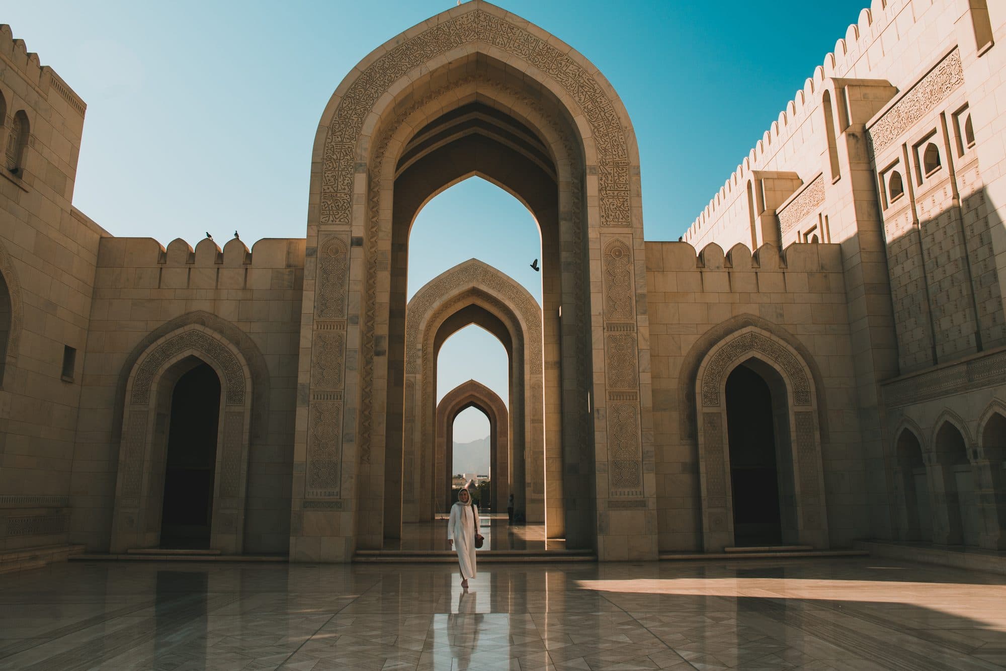 Marble arches leading into the courtyard of the Sultan Qaboos Grand Mosque